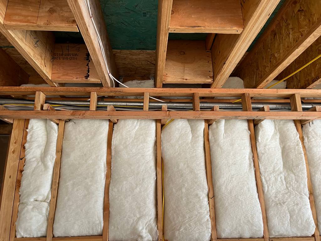  stud wall with rolled fiberglass insulation placed between the vertical wooden studs for improved energy efficiency and temperature regulation.