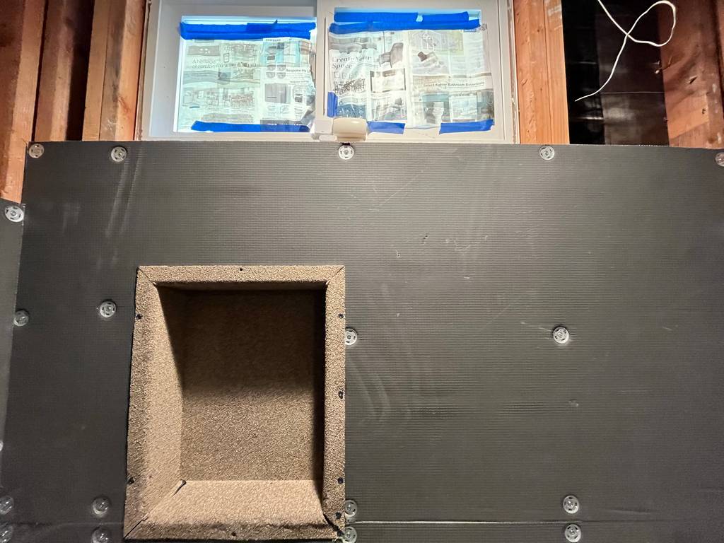 professional tile installer has built a shower niche into the wall.  around the opening you can see Hydro blok wallboard has been secured to the frame.