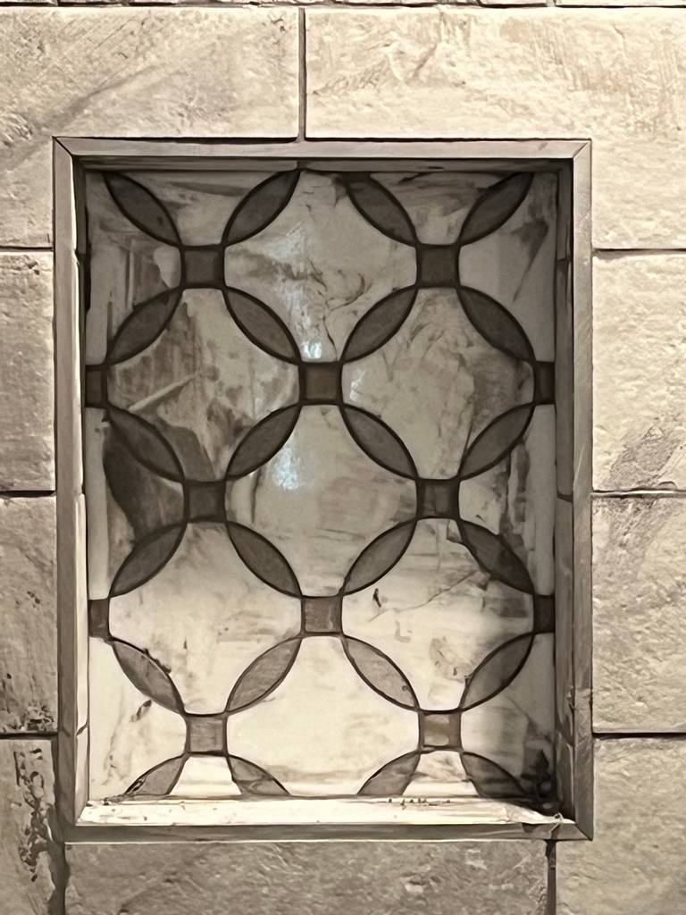 Uniquely designed shower niche capturing tile design.