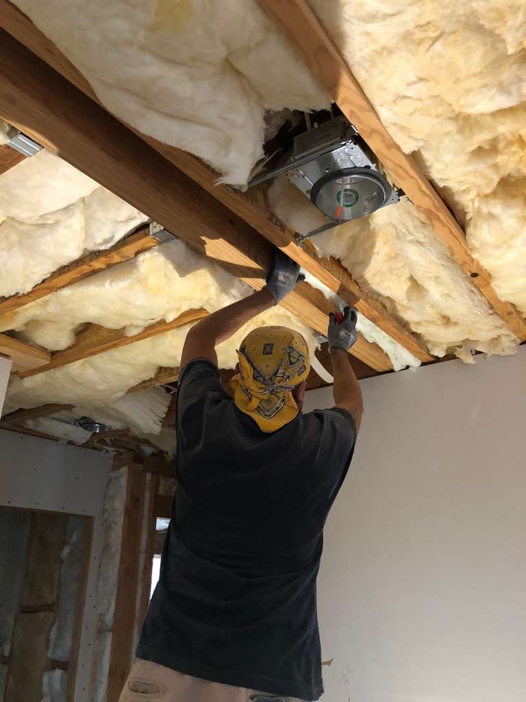 worker-installing-fiberglass-batts-installed-between-ceiling-joist