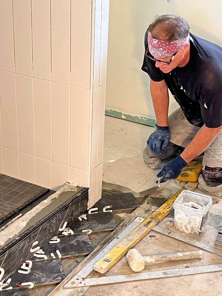 skilled tile worker secusing floor tiles