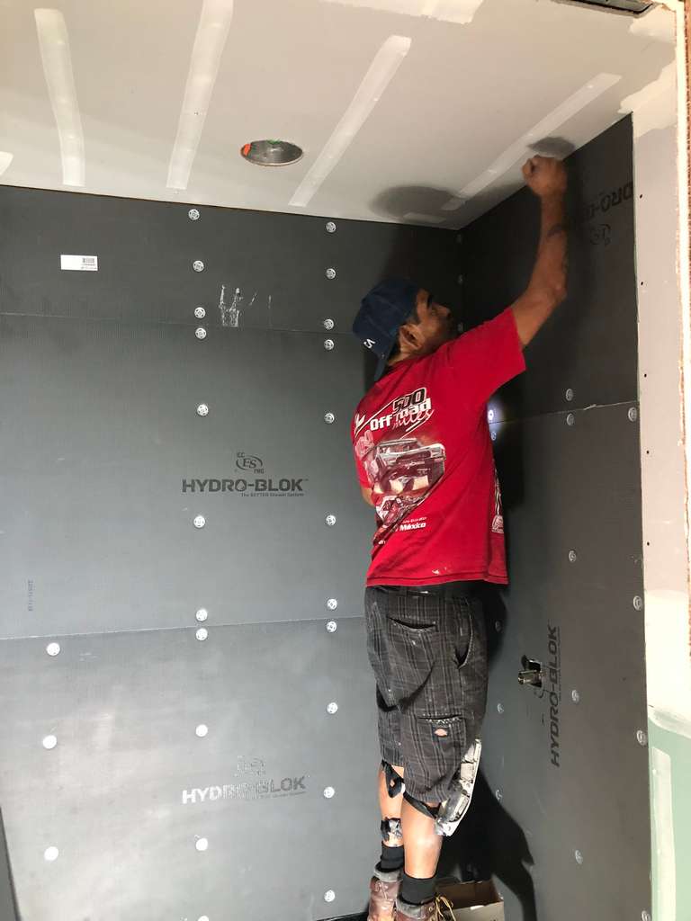 drywall-worker-fastening-shower-wall-panels