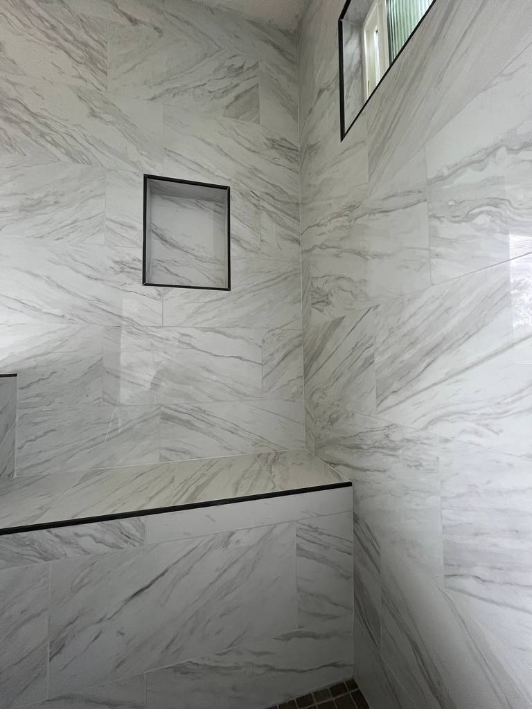 Elegant marble tiles installation with built-in shower seat and niche