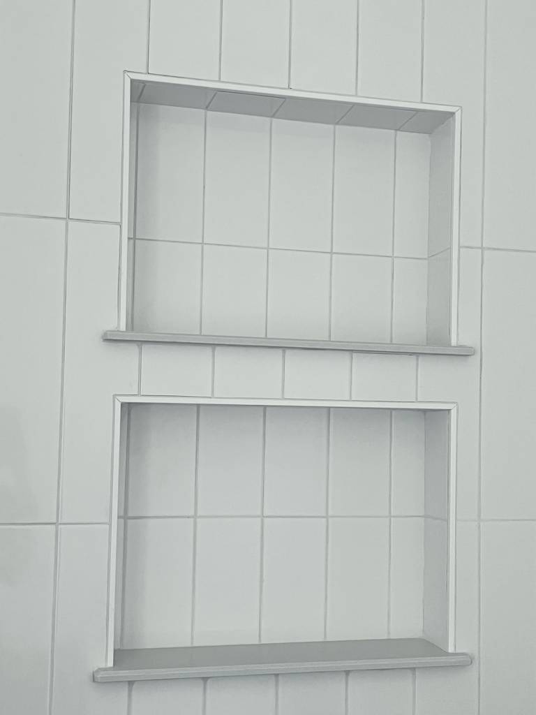 dual shower alcoves, providing convenient spaces for storage and enhancing the overall shower experience
