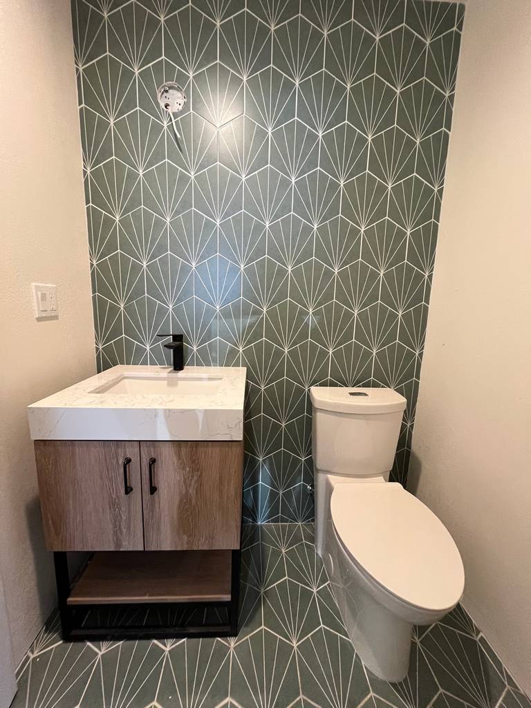   Stylish bathroom design custom vanity low-profile toilet elegant tile pattern.