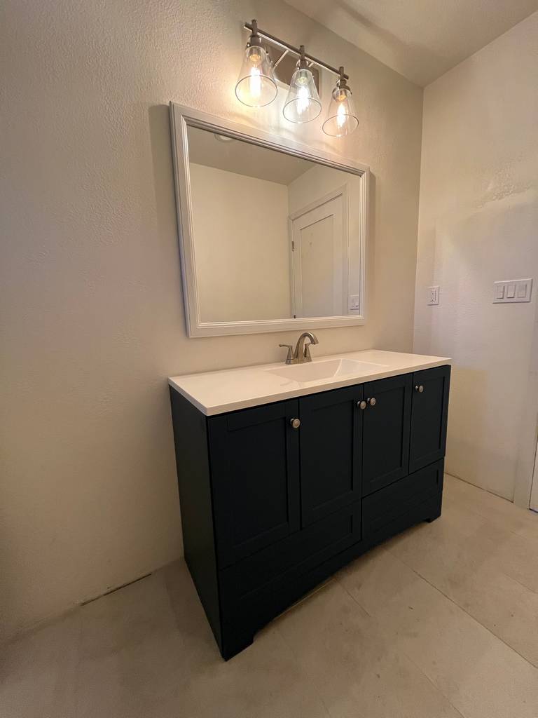 Residential contractor bathroom renovations custom vanities marble basins lights white-framed mirrors tiled floor