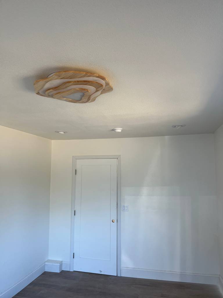 Artistic wood flush mount ceiling light frosted glass in room decor.
