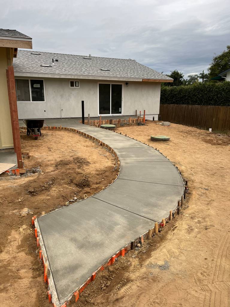 newly pored concrete pathway to pation of the home addition