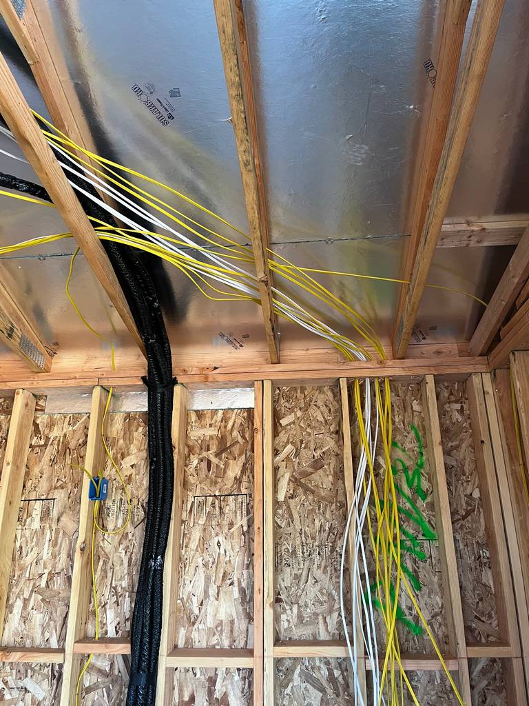 group of romex wires routed in open wall and ceiling